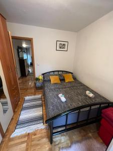 a bedroom with a bed with yellow pillows on it at Apartman West - private parking place in Zagreb