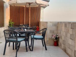 una mesa y sillas con una sombrilla en el patio en Jumeirah pyramids view inn, en El Cairo