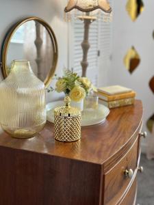 a wooden dresser with a mirror and a vase on it at Ty Cwm - Cwmcarn Valley House in Cwmcarn