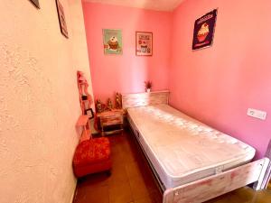 ein Schlafzimmer mit einem Bett in einer rosa Wand in der Unterkunft Cosy room near beach and University in Valencia