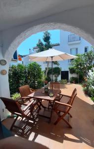a table and chairs with an umbrella on a patio at Precioso apartamento a pie de playa en la nueva Milla de Oro entre Estepona y Marbella in Estepona