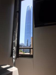a window with a view of a tall building at Apart Las Condes Espaço inteiro no bairro El Golf in Santiago