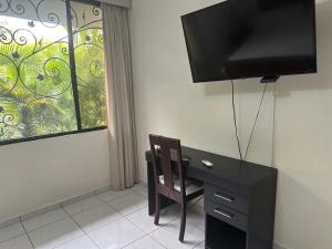 a room with a desk and a tv and a window at Casa Pamplona in San Salvador