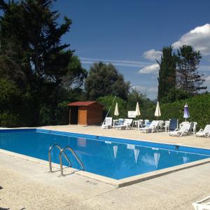 a swimming pool with lounge chairs and umbrellas at Villa Finetti in Gubbio
