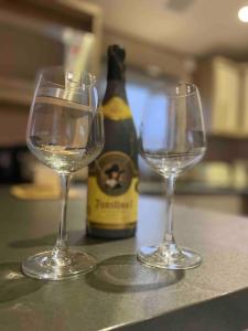 dois copos de vinho num balcão com uma garrafa de vinho em The Fairways Hideaway - Northumberland em Newbiggin-by-the-Sea
