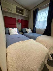 1 dormitorio con 2 camas y ventana en The Fairways Hideaway - Northumberland, en Newbiggin-by-the-Sea