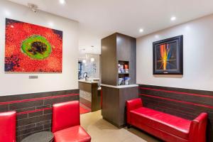 a bar with red chairs and a painting on the wall at Best Western Plus Hospitality House Suites in New York