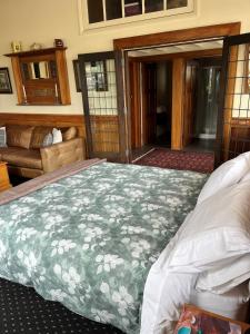 a bedroom with a bed with a green and white blanket at Bramley's Stables and Accommodation in Rangiora
