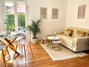 a living room with a couch and a table at Maison Bobochic parking et jardin by Art de Voyager in Étretat