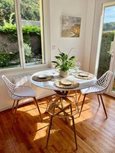 a dining room table with chairs and a potted plant at Maison Bobochic parking et jardin by Art de Voyager in Étretat