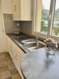 a kitchen with a sink and a counter top at Maison Bobochic parking et jardin by Art de Voyager in Étretat
