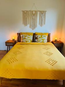 a large yellow bed in a bedroom with two tables at Maison Bobochic parking et jardin by Art de Voyager in Étretat