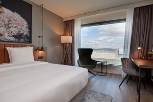 a hotel room with a bed and a desk and a window at Radisson Blu Hotel Zurich Airport in Kloten