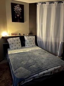 - une chambre avec un lit et une fenêtre avec un rideau dans l'établissement Yana House 1, à Corbeil-Essonnes