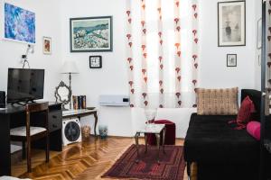 uma sala de estar com um sofá e uma televisão em Apartment Morgan - Historic Old Town Sarajevo em Sarajevo