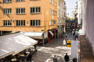 um grupo de pessoas andando por uma rua com edifícios em Apartment Morgan - Historic Old Town Sarajevo em Sarajevo