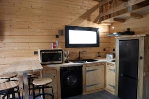 a kitchen with a stove and a sink and a microwave at Cab-Appart Mont de Marsan in Mont-de-Marsan