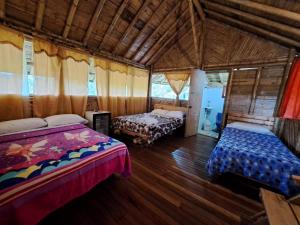 1 dormitorio con 2 camas y suelo de madera en Hotel Guatape Adrianas Bambu, en Guatapé