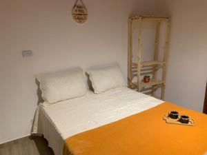 ein Bett mit zwei Kissen und einer Uhr an der Wand in der Unterkunft Sítio Terra Sertaneja - Chalé Um Sonhador in Piedade