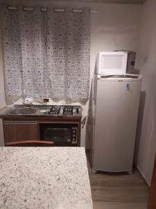 uma pequena cozinha com frigorífico e micro-ondas em Sítio Terra Sertaneja - Chalé Um Sonhador em Piedade