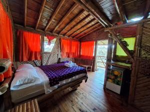 1 dormitorio con 1 cama en una habitación con cortinas rojas en Hotel Guatape Adrianas Bambu, en Guatapé