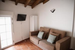 een woonkamer met een bank en een televisie bij VIVE Trujillo in Trujillo