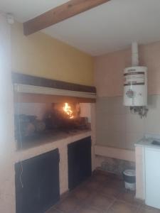 a kitchen with a fireplace in the corner of a room at Maipú soñado in Maipú