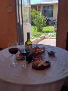 a table with a bottle of wine and wine glasses at Maipú soñado in Maipú