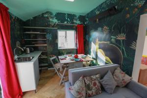 a living room with a couch and a table and a kitchen at The Writer's Studio (stylish garden guesthouse) 