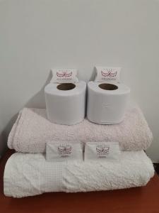 tres rollos de papel higiénico encima de las toallas en Hotel los angeles, en Huaral