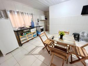 uma cozinha com uma mesa e cadeiras e um frigorífico em Apartamento Simples e completo em Maragogi