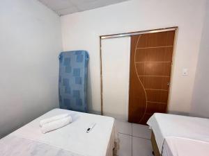 um pequeno quarto com 2 camas e um chuveiro em Apartamento Simples e completo em Maragogi