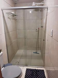 um chuveiro com uma porta de vidro na casa de banho em Apartamento Simples e completo em Maragogi