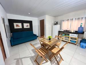 uma sala de estar com uma mesa e cadeiras e um sofá em Apartamento Simples e completo em Maragogi