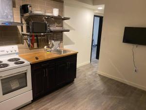 a kitchen with a sink and a stove top oven at Brand New Dt 1 Br Close To All Edmonton, Canada in Edmonton