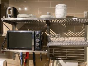 eine Mikrowelle auf einem Regal in einer Küche in der Unterkunft Brand New Dt 1 Br Close To All Edmonton, Canada in Edmonton