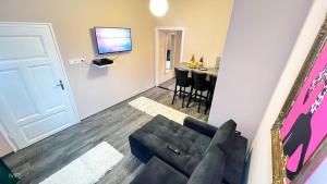 a living room with a couch and a table at Flamingo Rezidencia Apartman in Eger
