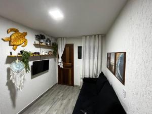 a living room with a couch and a tv at Meu Loft Barra Nova 4 in Saquarema