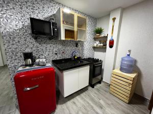a small kitchen with a red refrigerator and a sink at Meu Loft Barra Nova 4 in Saquarema