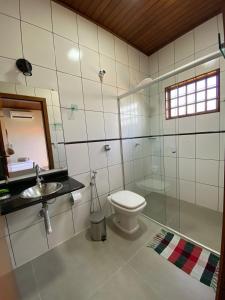 a bathroom with a toilet and a sink and a mirror at Pousada Portal do Cerrado in Pirenópolis