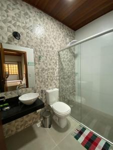 y baño con aseo, lavabo y ducha. en Pousada Portal do Cerrado en Pirenópolis