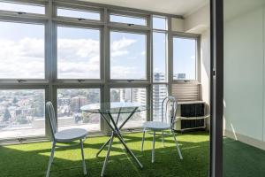 a table and two chairs in a room with windows at Burwood 1bedroom Apartment next to Station in Sydney