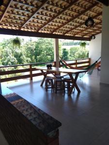 Casa ampla com piscina في بيوي: طاولة وكراسي على شرفة مع أرجوحة
