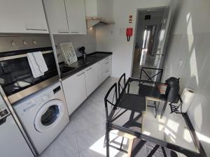 a kitchen with a washing machine and a table and chairs at Sintra, T3 with terrace in Massama, Queluz, Sintra in Queluz