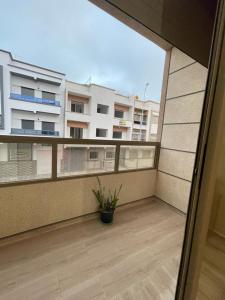einen Balkon mit Topfpflanze und einem Gebäude in der Unterkunft Chez Soad in Bouznika