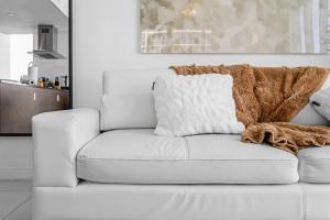 un sofá blanco con una almohada encima en Luxurious Condo at ICON with Views, en Miami