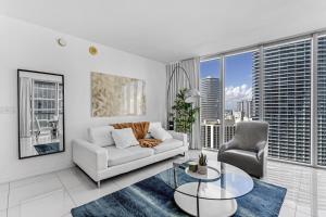een woonkamer met een witte bank en een glazen tafel bij Luxurious Condo at ICON with Views in Miami