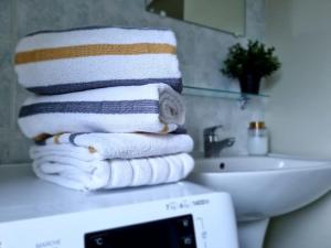 een stapel handdoeken op een aanrecht in de badkamer bij Le Saint-Gildas - parking privé - Belle Isle in Châteauroux
