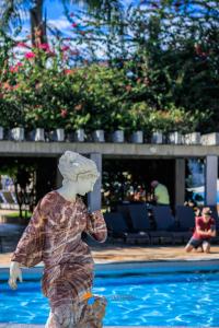 una estatua de un niño parado frente a una piscina en Apartamentos 2 Quartos- Lacqua diRoma Caldas Novas, en Caldas Novas