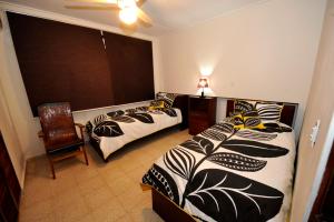 una camera con due letti e una sedia e una finestra di Totumas Lodge a Città di Panama